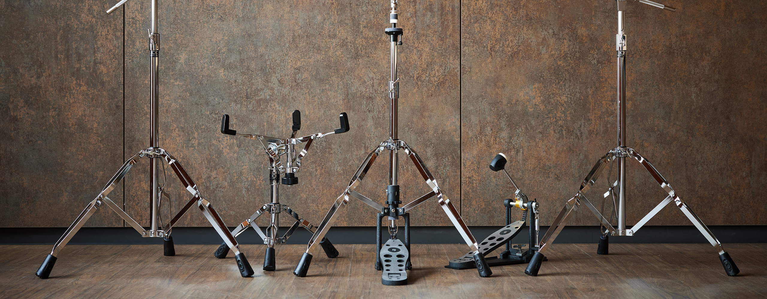 DrumCraft Series 4 hardware set, including stands and pedals, displayed against a rustic backdrop.